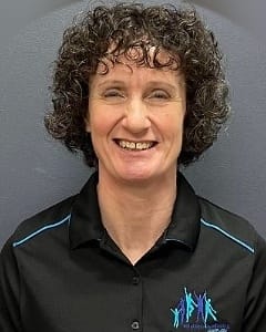 Kate Watkins, physiotherapist, smiling in a Solutions4Wellbeing polo